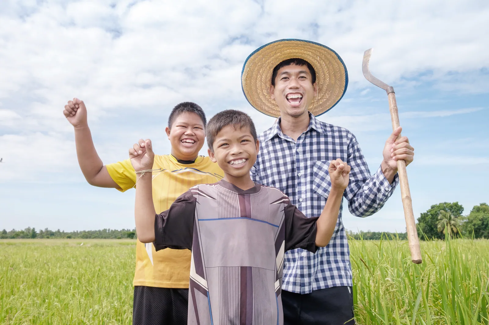Farming family standing together in a rice field